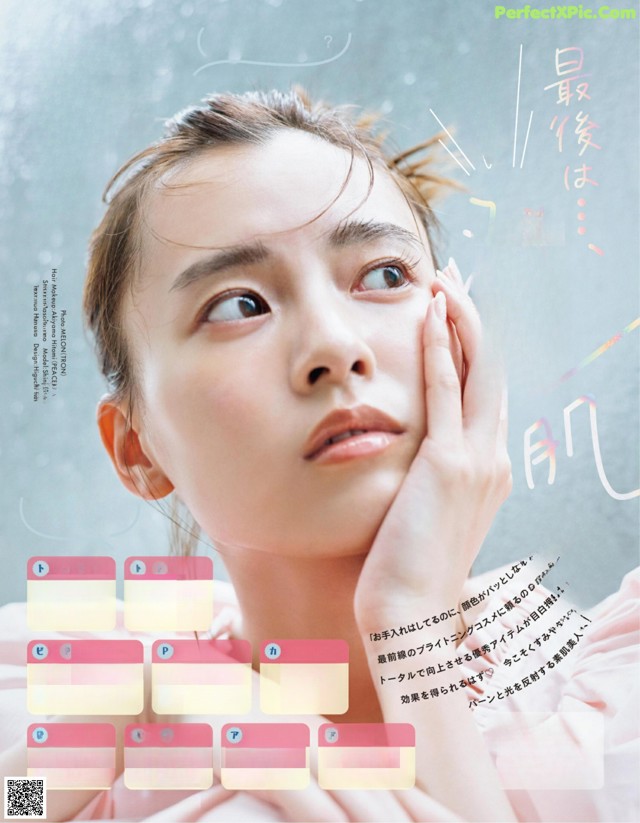 A magazine with a picture of a woman with her hand on her face.