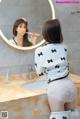 A woman brushing her teeth in front of a mirror.