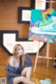 A woman sitting on the floor in front of a painting.