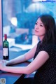 A woman sitting at a table with a glass of wine.