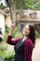 A woman holding a flower in her hand. 