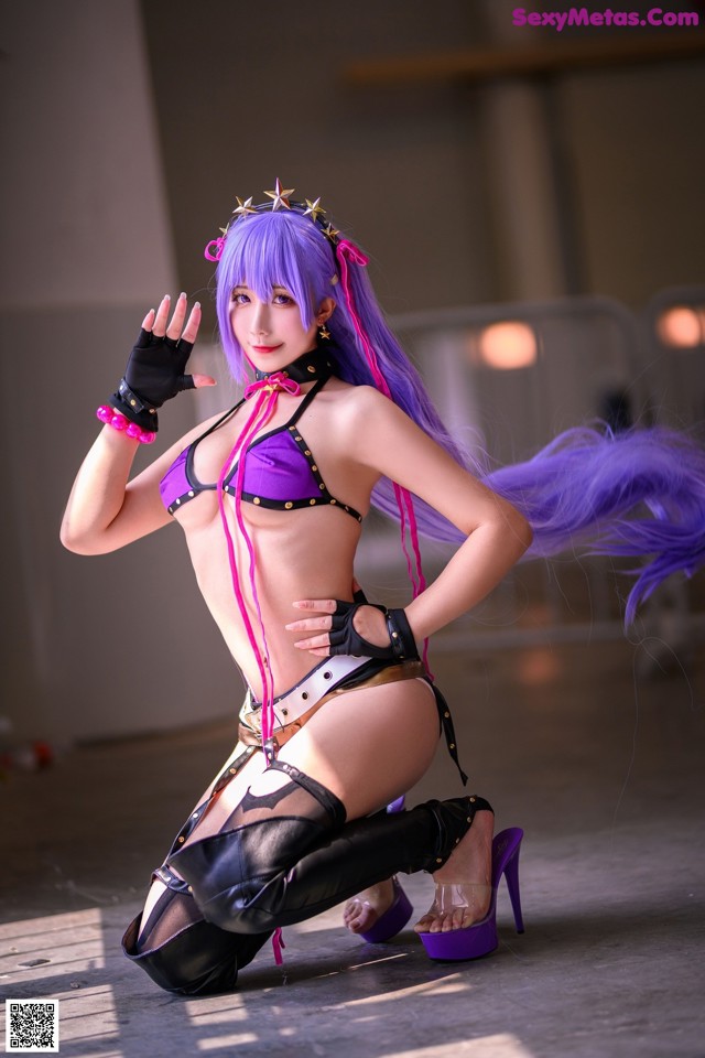 A woman in a purple and black outfit posing for a picture.