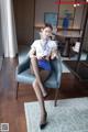 A woman sitting on a blue chair in a room.