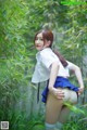 A woman in a white shirt and blue skirt posing in a bamboo forest.