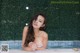 A woman in a white bikini sitting in a pool.