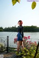 A woman standing on a wooden deck next to a body of water.