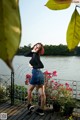 A woman standing on a wooden deck next to a body of water.