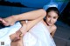 A woman in a wedding dress laying on a dock.